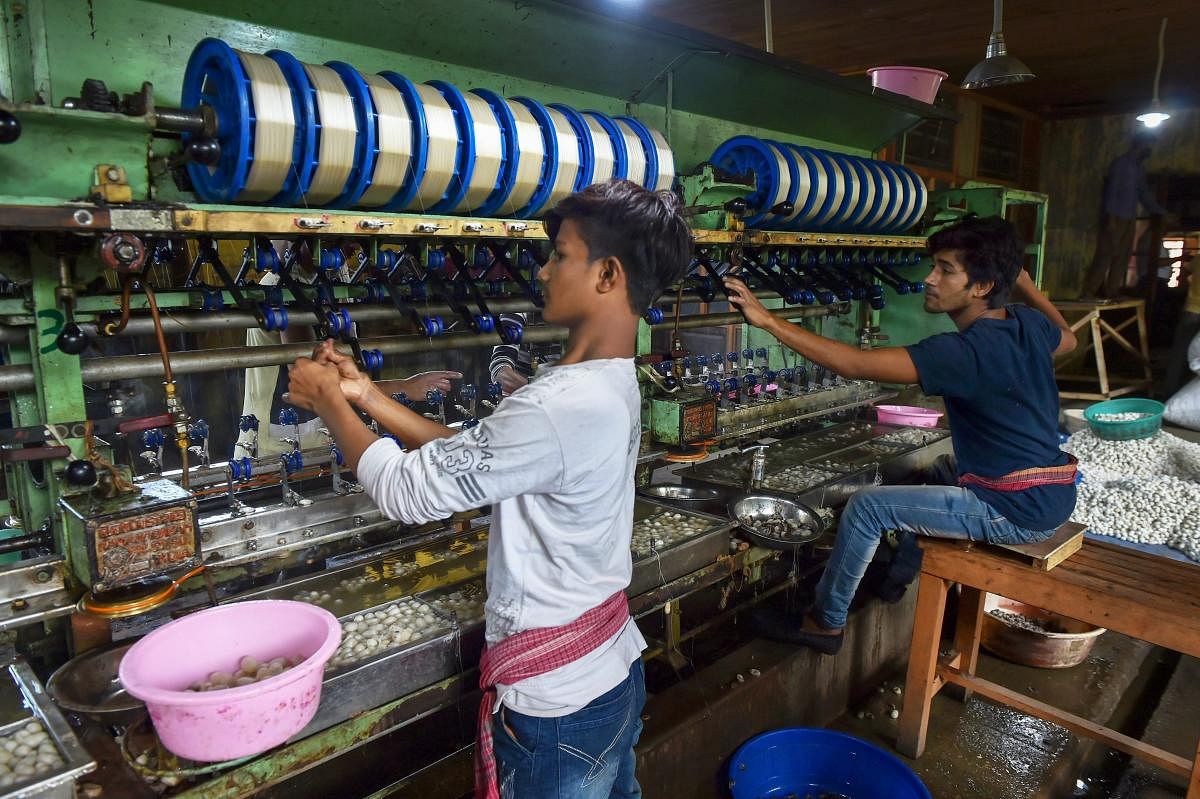 Labourers work with Mulberry cocoons inside the silk factory at Solina, in Srinagar. (PTI Photo)