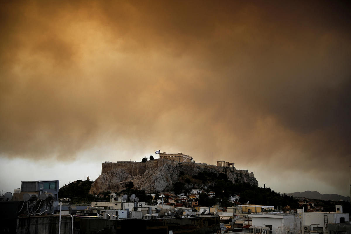 Smoke from a wildfire burning outside Athens is seen over the Parthenon temple atop the Acropolis hill in Athens, Greece. (Reuters Photo)