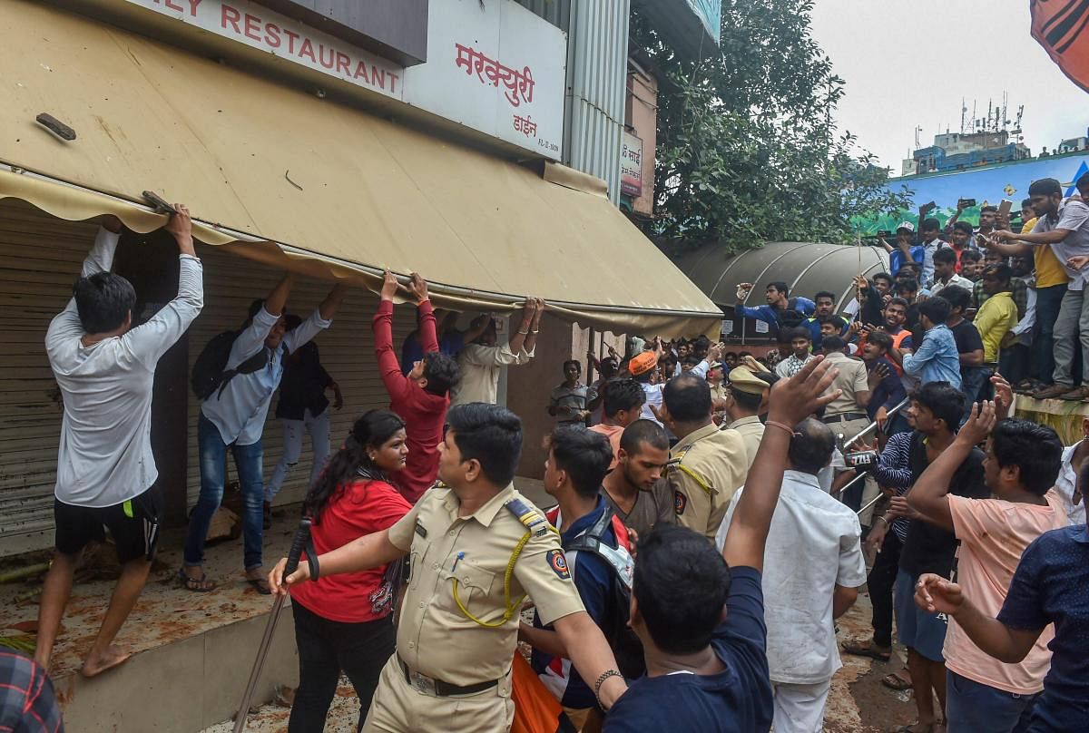 Police personnel lathi charge Maratha Kranti Morcha protesters who were vandalising store fronts during their statewide bandh, called for reservations in jobs and education protesters, in Thane. (PTI Photo)