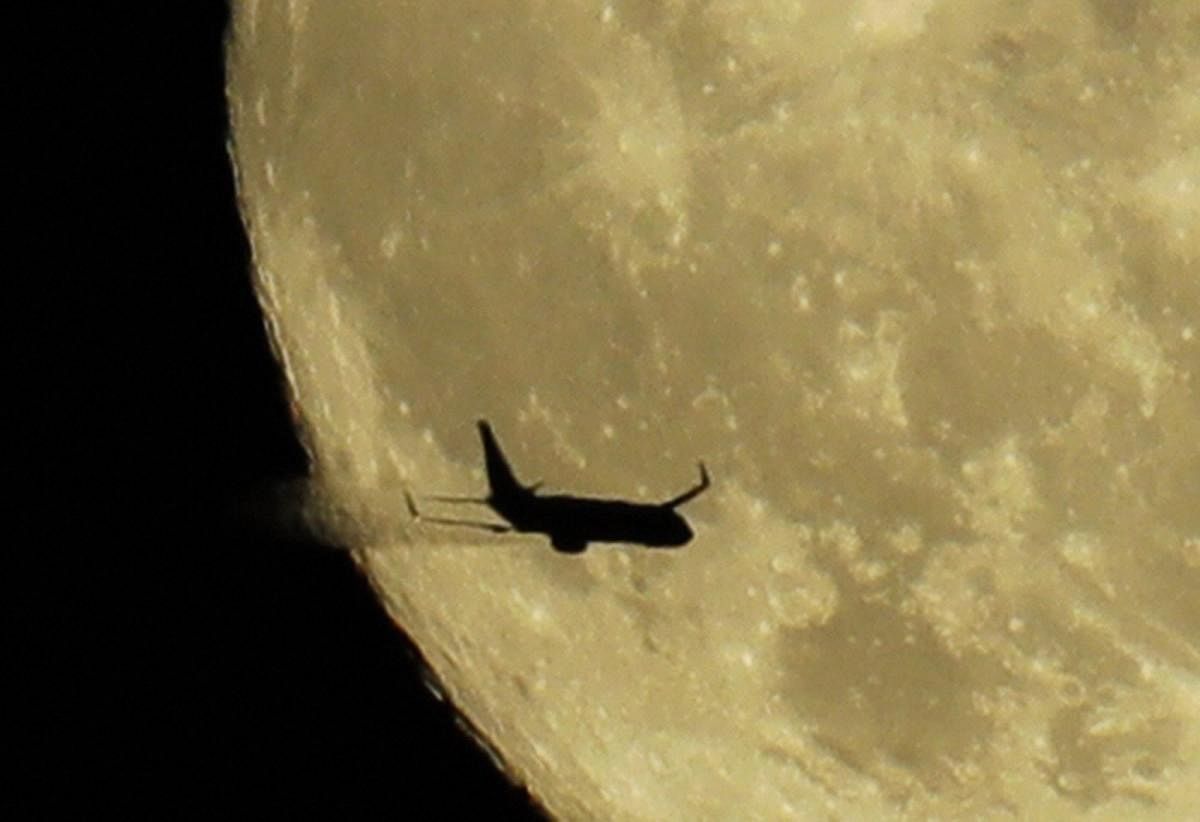 Tacoma : An airplane leaves a vapor trail as it passes in front of a nearly full moon above Tacoma, Wash., Thursday, July 26, 2018. AP/PTI
