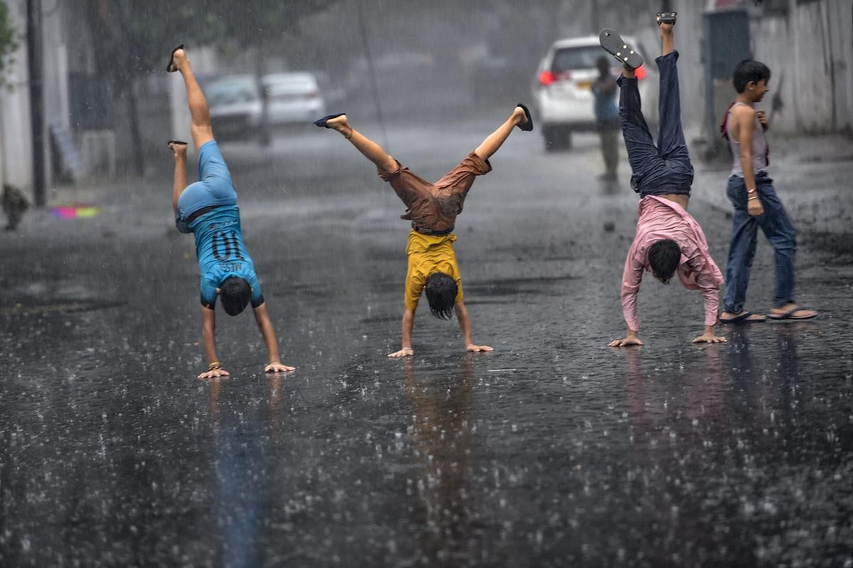 Children enjoy the Monsoon rains, in New Delhi on Friday, Aug 10, 2018. (PTI Photo)