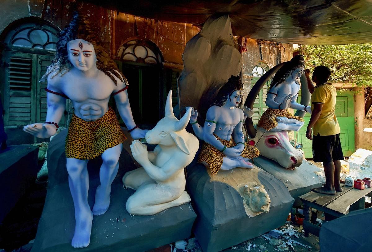 An artist gives finishing touches to the idols of Lord Shiva at his workshop during the holy month of Shravan in Kolkata on Friday, August 10, 2018. (PTI Photo)