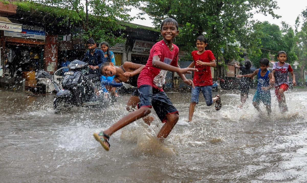Children play on a waterlogged street during rainfall, in Amritsar. (PTI Photo)
