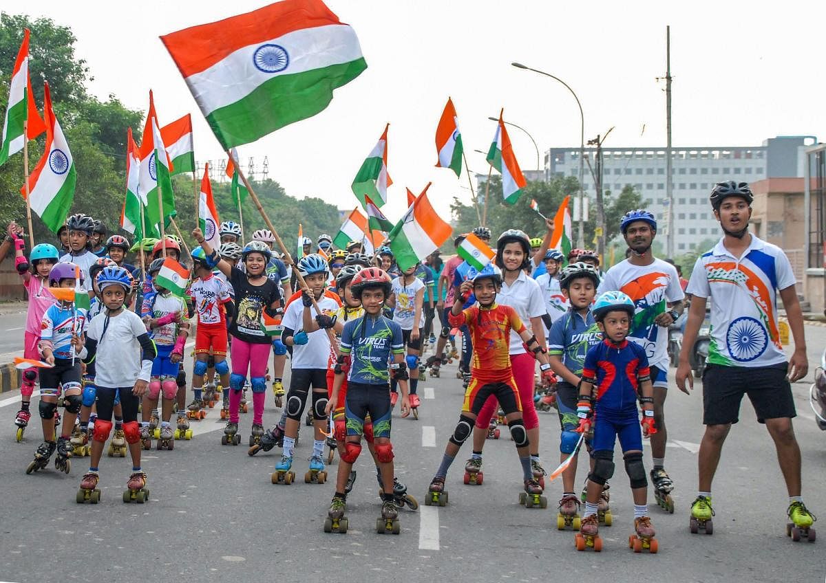 Children, holding tricolours, take part in a skating-rally to celebrate the 72nd Independence Day, in Noida on Wednesday. (PTI Photo)