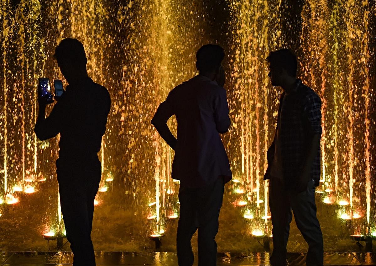 People stand near a fountain as they celebrate the 72nd Independence Day, in New Delhi on on Wednesday, Aug 15, 2018. (PTI Photo)