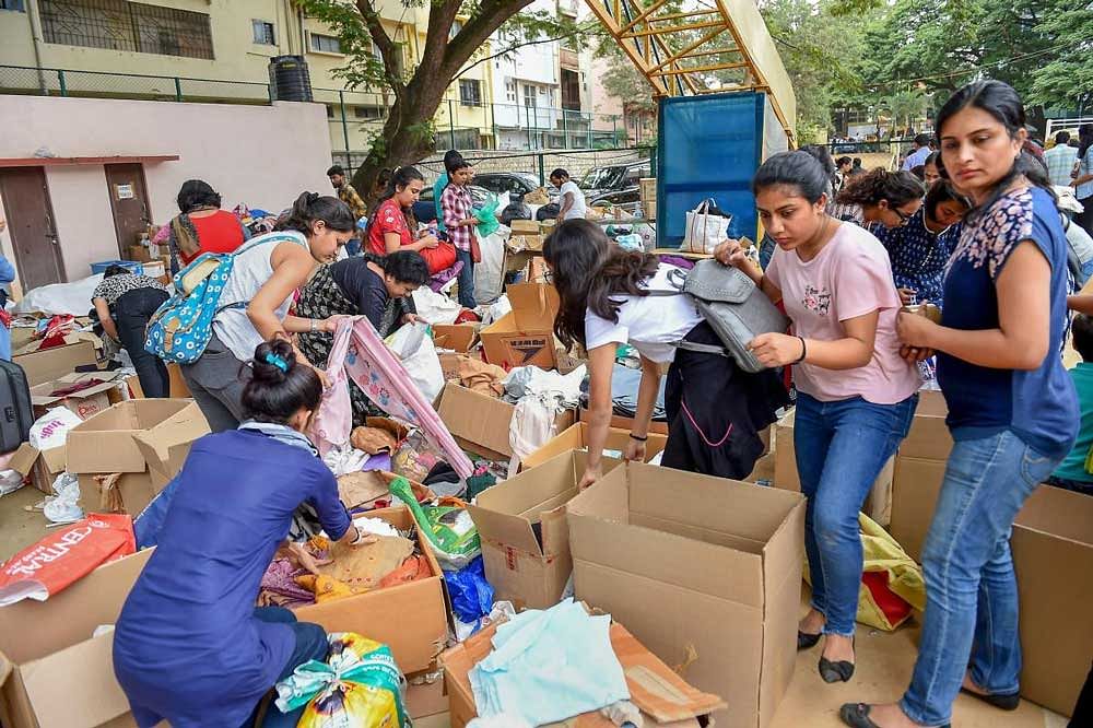 Volunteers segregate relief material to be sent to Kodagu area at Kodava Samaj, in Bengaluru on Sunday, Aug 19, 2018. At least six people have died and over 11,000 houses damaged in rain-related incidents so far. PTI Photo