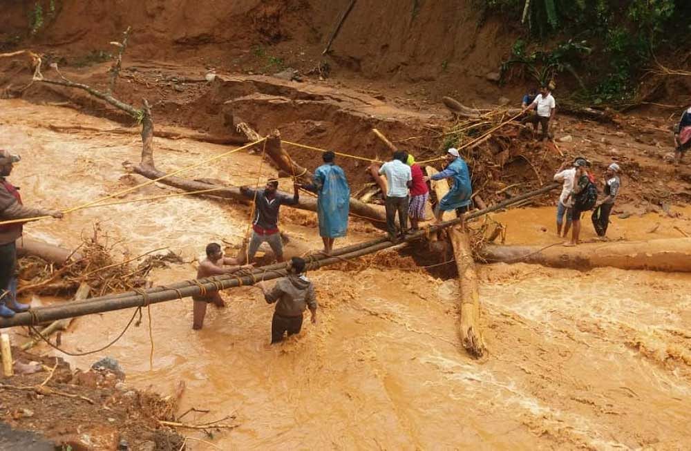 Victims are rescued using a makeshift bridge from the hilly ranges in Kodagu district. DH Photo