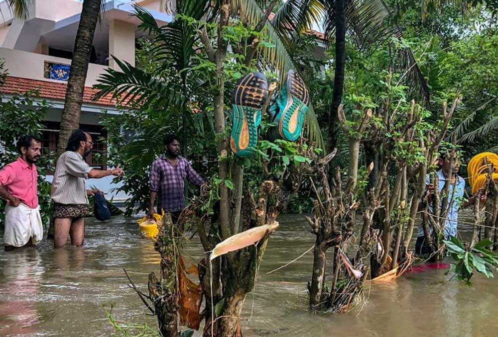 People in a flood-hit locality in Thrissur district on Monday. PTI Photo