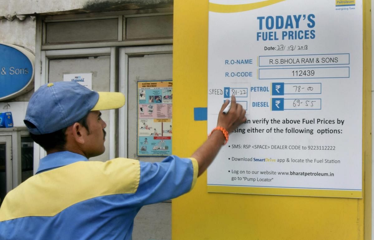 An employee writes the updated fuel prices on a board at a filling station, in New Delhi on Monday, August 27, 2018. Oil Marketing Companies (OMCs) on Monday increased the prices of petrol and diesel across four metros of the country. PTI