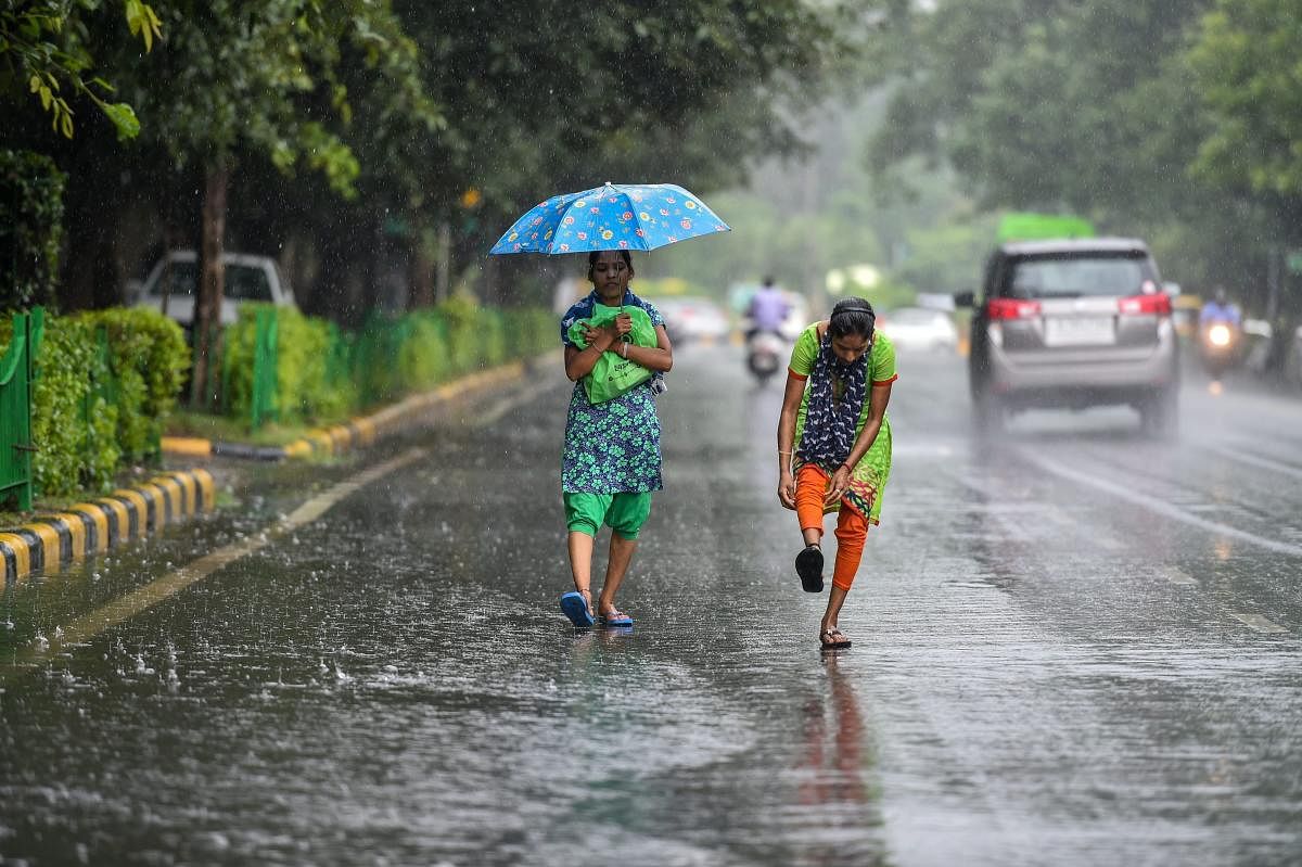 Pedestrians use an umbrella during monsoon rainfall, in New Delhi on Wednesday, Aug 29, 2018. PTI