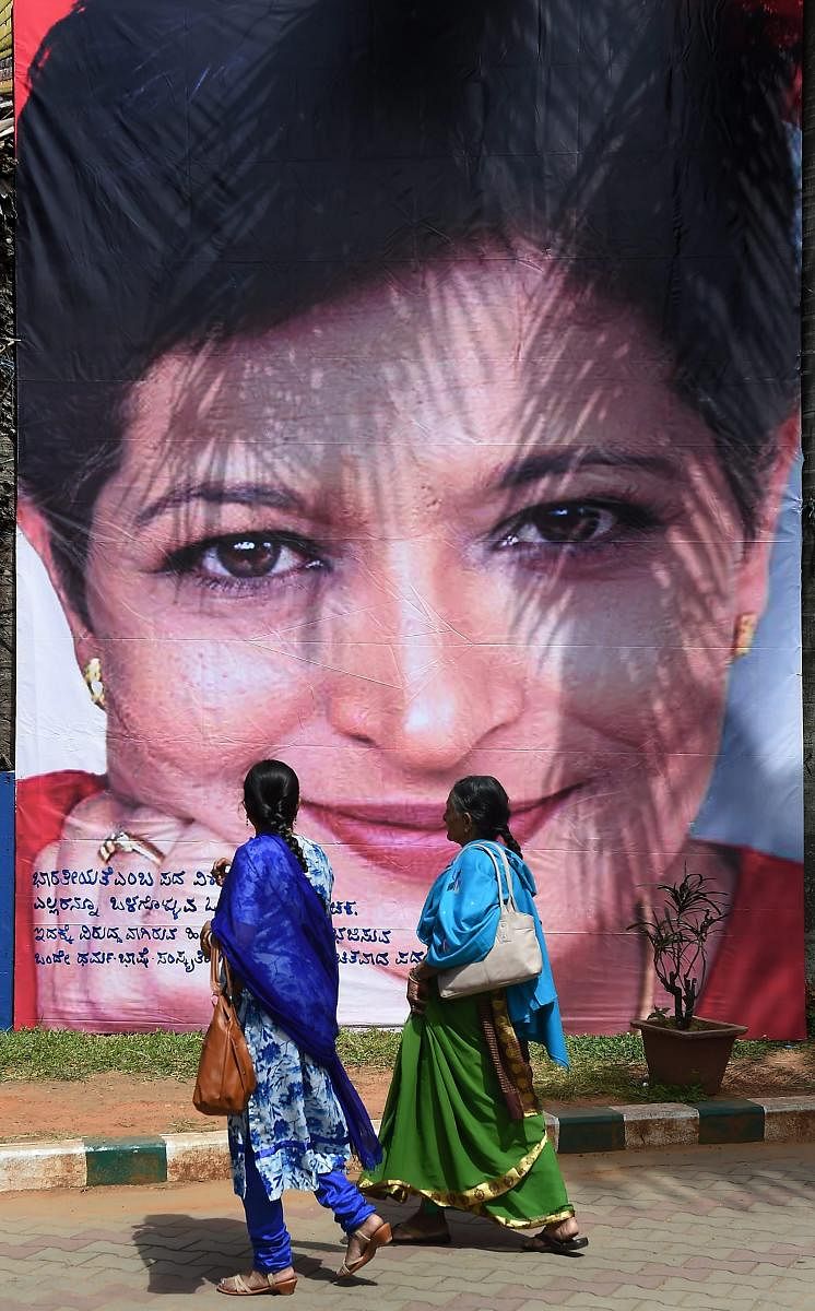 Two women walk past a poster of slain journalist Gauri Lankesh during the 'Freedom of Expression Meet', organised on the occasion of first death anniversary of Gauri, in Bengaluru, Wednesday, Sept 5, 2018. (PTI Photo/Shailendra Bhojak)