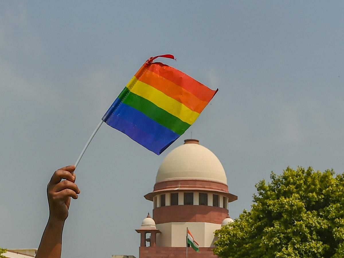 An activist waves a rainbow flag (LGBT pride flag) after the Supreme Court verdict which decriminalises consensual gay sex, outside the Supreme Court in New Delhi, Thursday. PTI photo