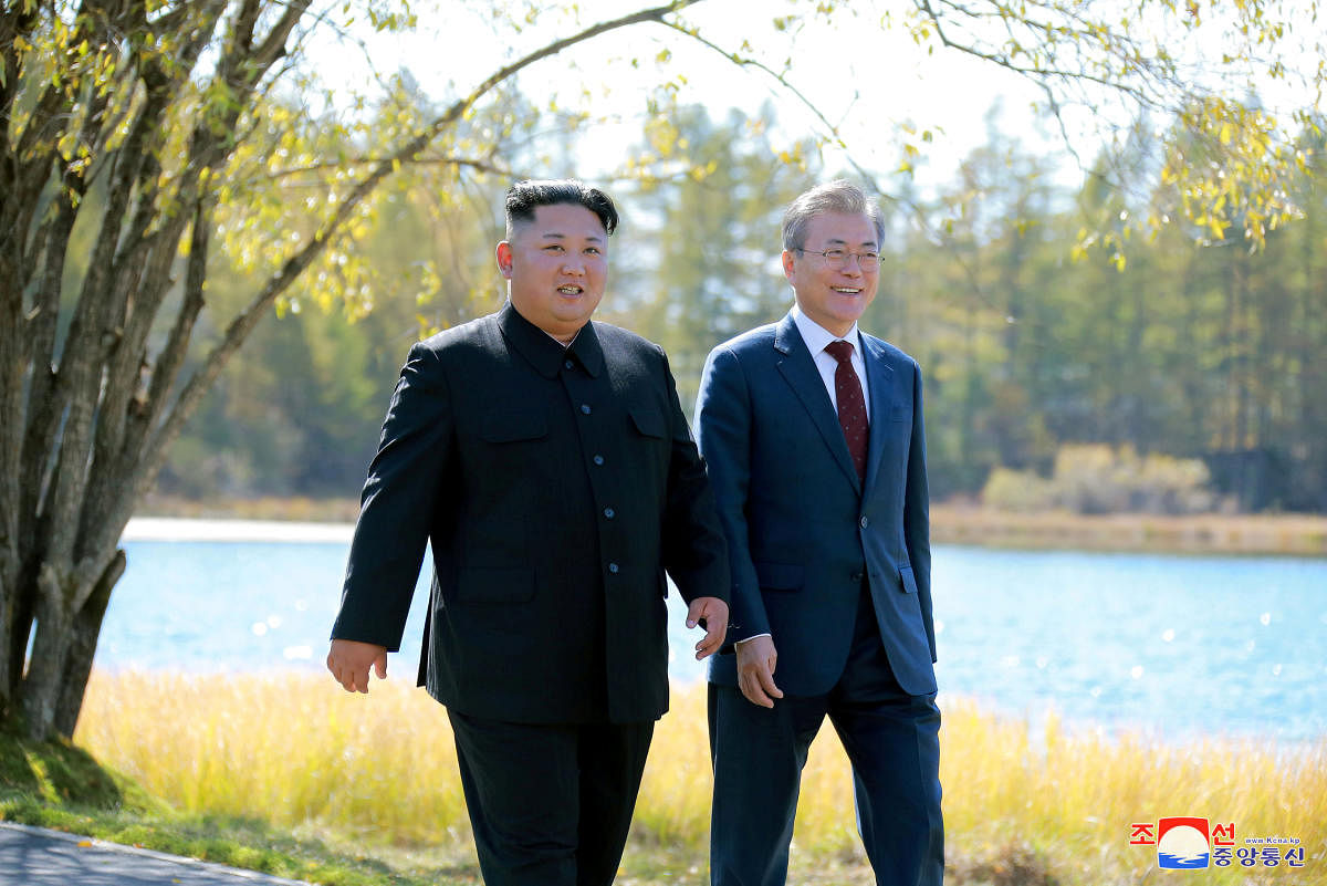 This picture taken on September 20, 2018 and released by Korean Central News Agency (KCNA) via KNS shows North Korea's leader Kim Jong Un (L) and South Korean President Moon Jae-in (R) walking together during a visit to Samjiyon guesthouse near Mount Paektu in Samjiyon. - Kim Jong Un and Moon Jae-in visited the spiritual birthplace of the Korean nation on September 20, for a show of unity after their North-South summit gave new momentum to Pyongyang's negotiations with Washington. (Photo by KCNA VIA KNS / various sources / AFP)