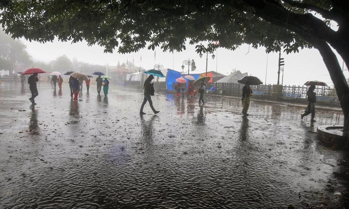Shimla: People protect themselves with umbrellas during heavy rains in Shimla, Saturday, Sep 22, 2018. (PTI Photo)