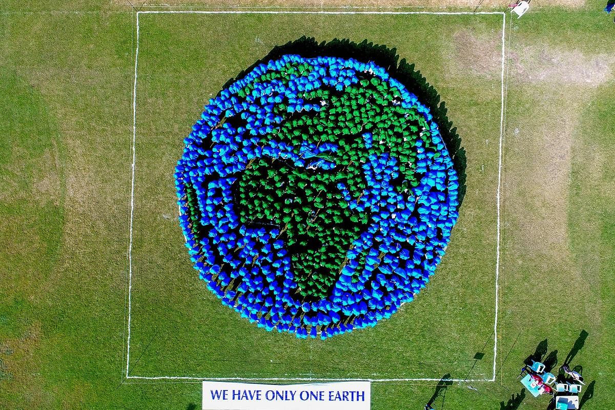 Surat: Students of Swaminarayan Gurukul makes a formation in the shape of the earth in Surat, Saturday, Sep 22, 2018. (PTI Photo)