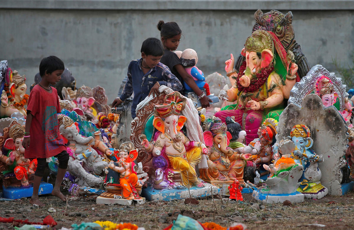 Children assemble idols of Hindu god Ganesh, the deity of prosperity, after collecting them from a pond a day after their immersion, in Ahmedabad, India, September 24, 2018. REUTERS/Amit Dave
