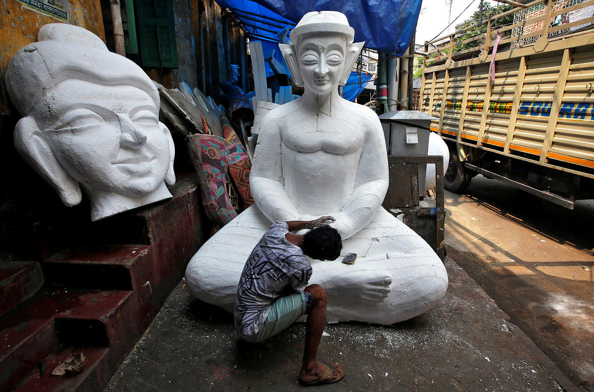 A man works on a Buddha idol made of polystyrene, which will be used to decorate a pandal, or a temporary platform, ahead of the Durga Puja festival in Kolkata, India September 25, 2018. REUTERS/Rupak De Chowdhuri