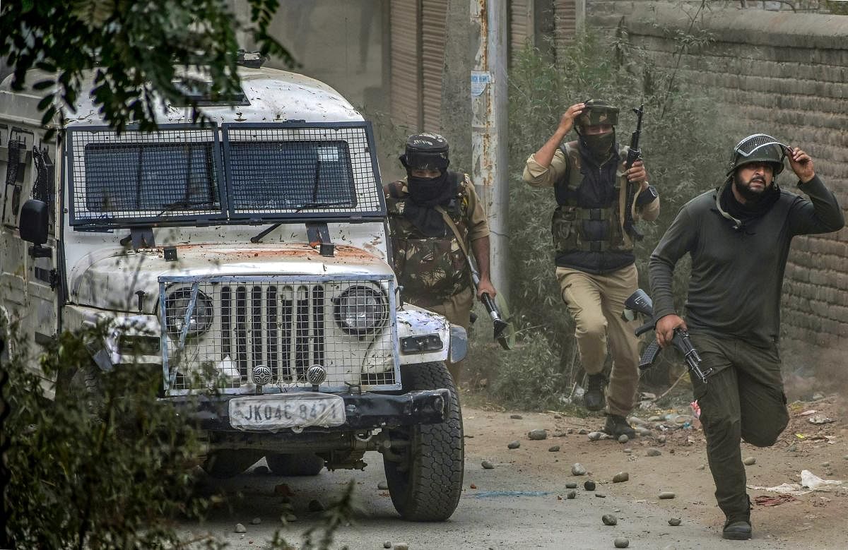 Budgam: Special Operation Group (SOG) of Jammu and Kashmir Police run towards the mosque where militants were hiding during an encounter, at Panzan Chadoora area of Budgam district near Srinagar, Thursday, Sept 27, 2018. Five persons, including three militants, were killed in three separate incidents. (PTI Photo)
