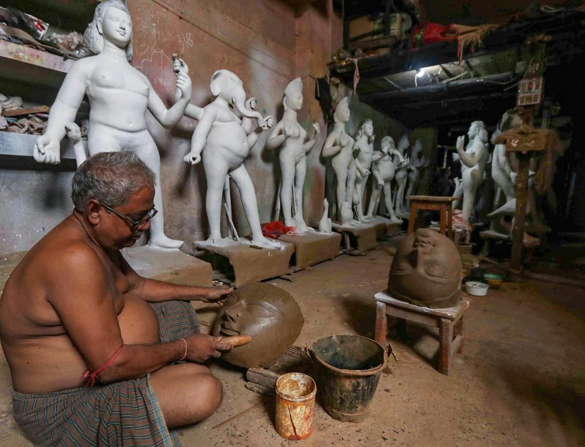 An artisan prepares an idol of Goddess Durga at his workshop ahead of Durga Puja festival, in Birbhum. (PTI Photo)