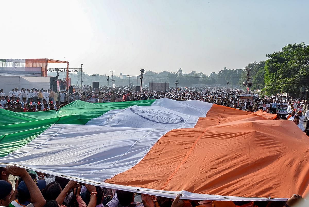 People carry an Indian tricolour to be placed at a height of 131ft ahead of its hoisting by Union Textile Minister Smriti Irani, in Muzzafarnagar, Tuesday, Oct 2, 2018. (PTI Photo)