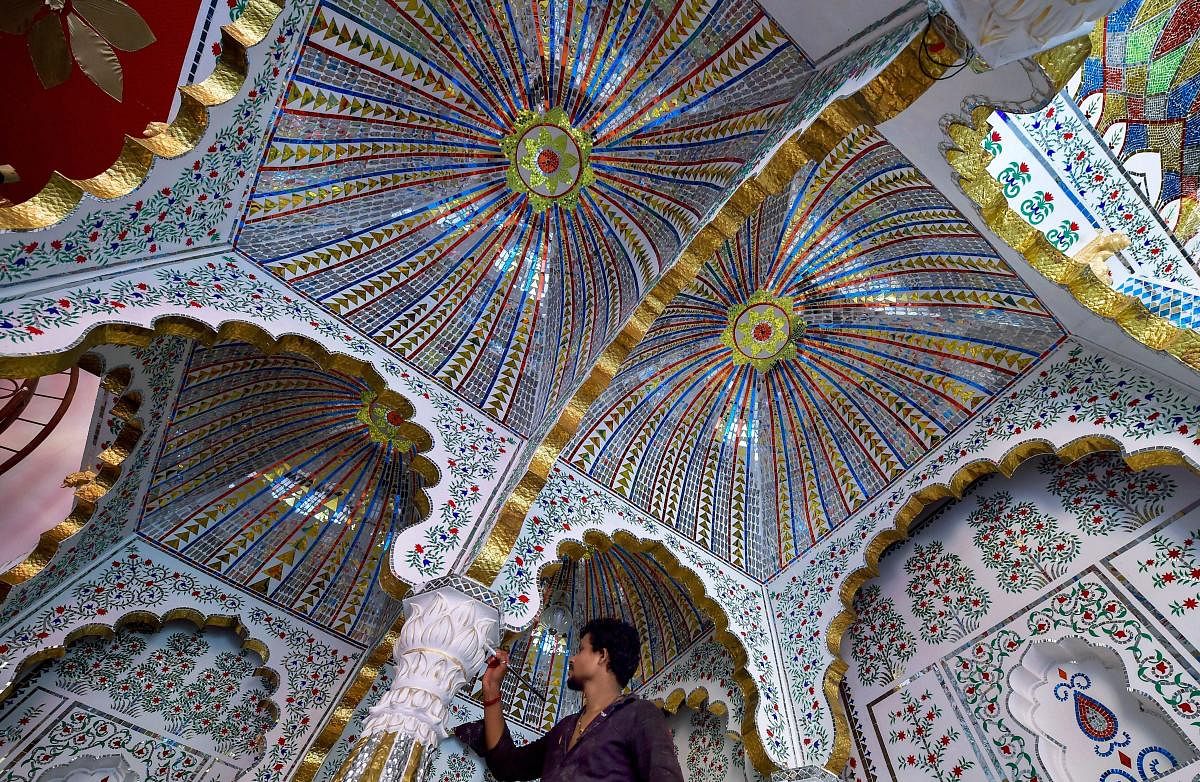 A worker busy in decorating a 'pandal' for the forthcoming Durga Puja celebrations, in Kolkata. (PTI Photo)