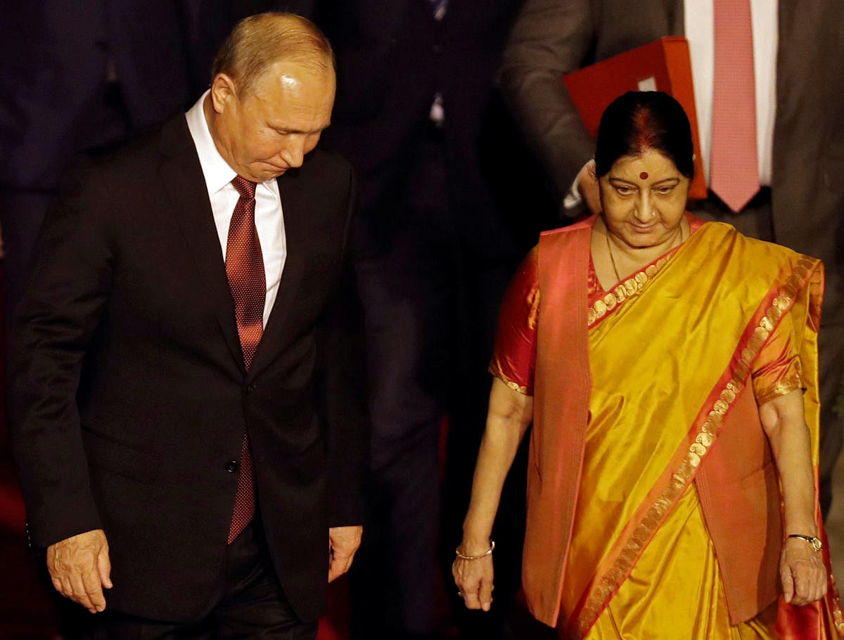 Russian President Vladimir Putin walks with India's Foreign Minister Sushma Swaraj upon his arrival at Air Force Station Palam in New Delhi. (Reuters Photo)