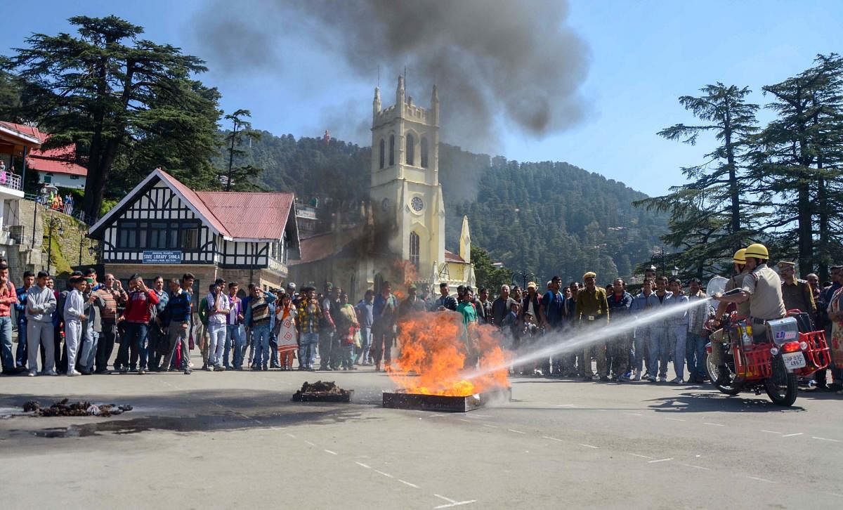 Firefighters extinguish fire during a demonstration on the occasion of International Day for Natural Disaster Reduction, at Ridge in Shimla. PTI