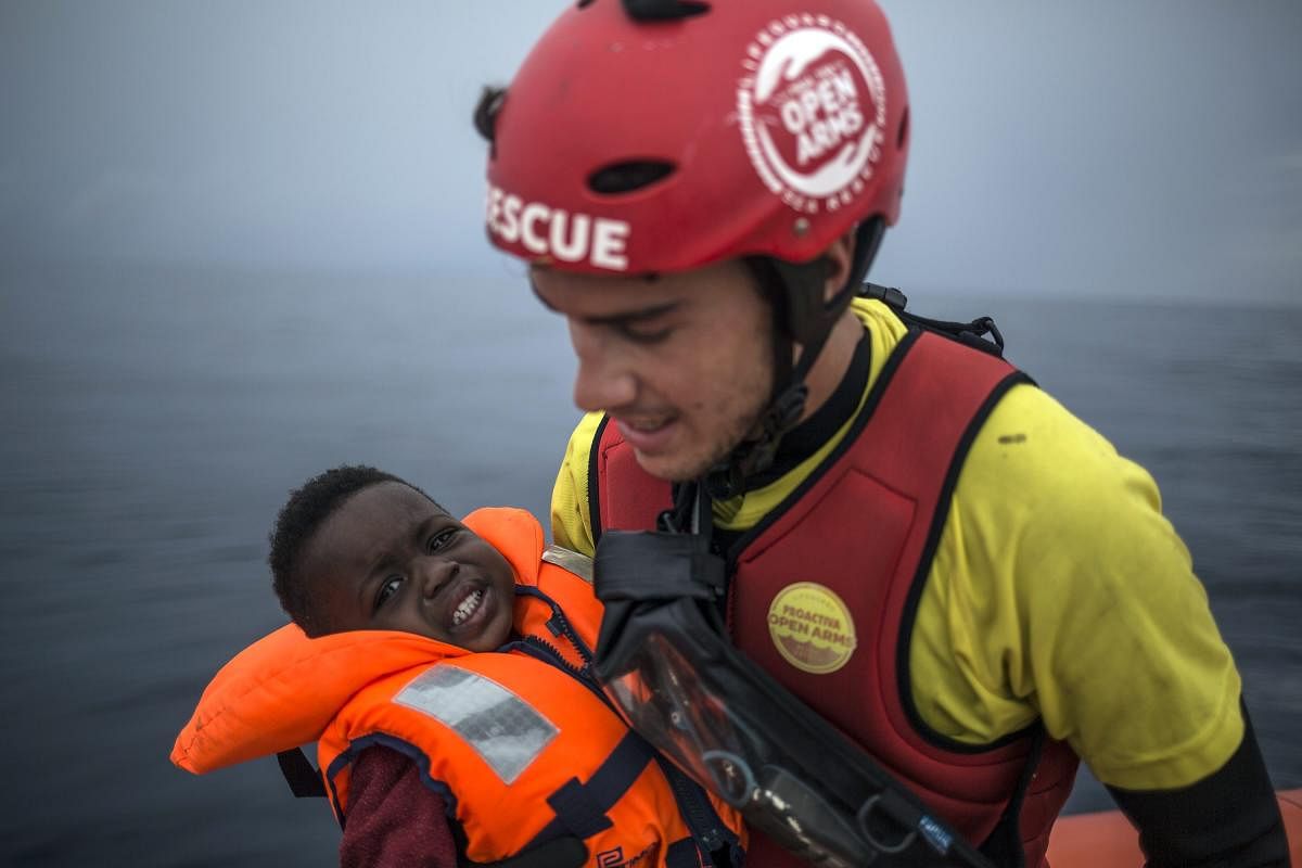 A member of Spanish NGO Pro activa Open Arms holds a baby rescued at a dinghy at Alboran Sea, about 40 miles (64 kms) from the Spanish coasts. The Open Arms is now based at Motril port in order to start operating in the western Mediterranean area. AP/PTI