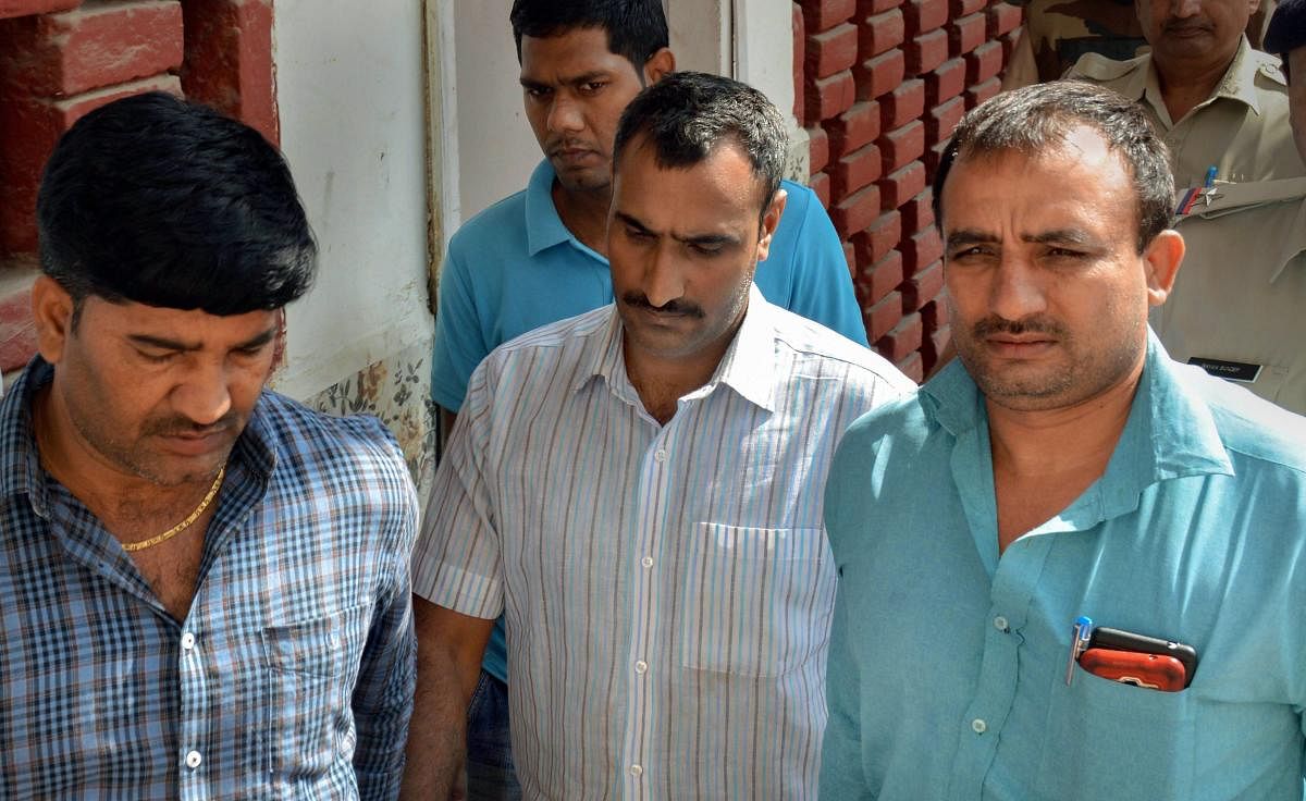 Police take Mahipal, who was accused of shooting the judge's wife and son, to a court, in Gurugram. PTI