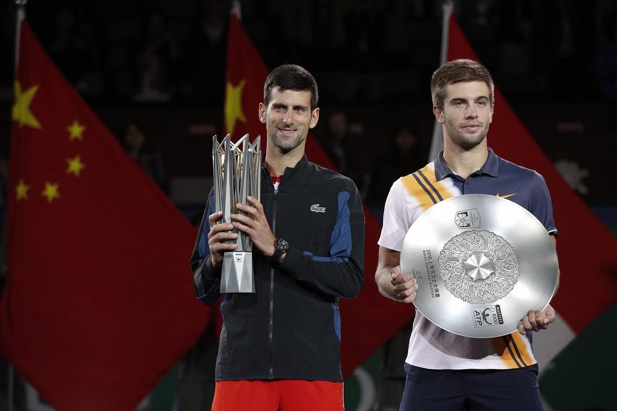 Winner's Novak Djokovic of Serbia, left, holding the winner's trophy and Borna Coric of Croatia pose with the runner-up trophy the award ceremony for the Shanghai Masters tennis tournament at Qizhong Forest Sports City Tennis Center in Shanghai, China. AP/PTI