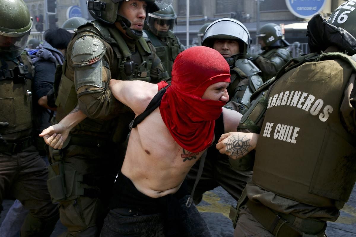 A protester is detained by police during a march against the commemoration of the discovery of the Americas, organized by indigenous groups demanding autonomy and the recovery of ancestral land, in Santiago, Chile. Protesters also demonstrated against Chile's anti-terrorism law, under which many Mapuche Indians are under arrest. AP/PTI