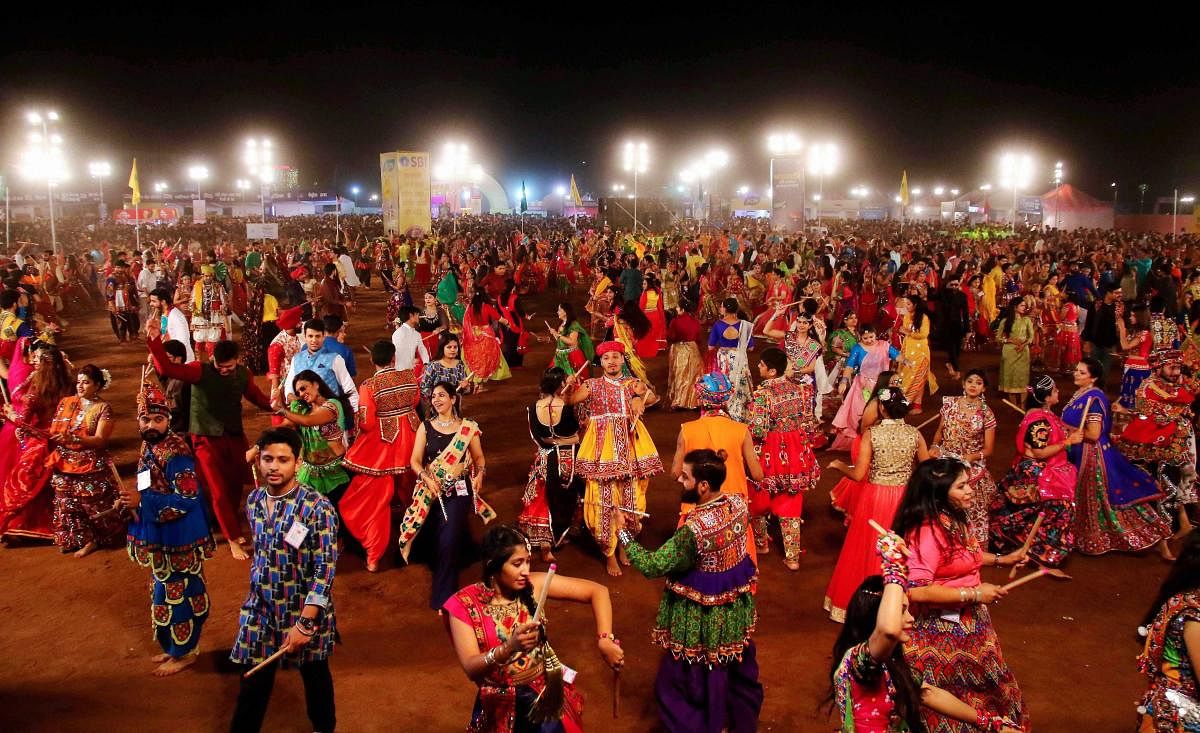 Youngsters, dressed in traditional attire, participate in mass 'Garba' and 'Dandiya' programme during Navratri celebrations, in Jaipur. PTI