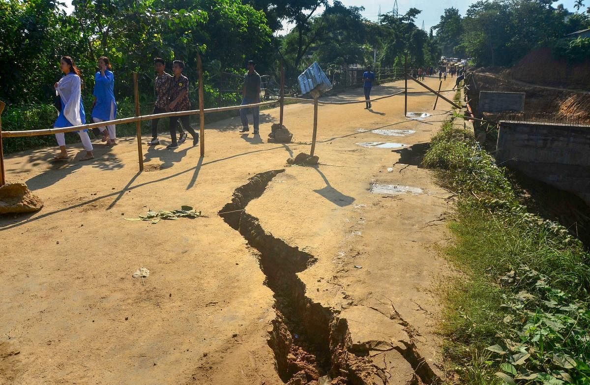 Pedestrians walk past a cracked Nagarjan bridge after continuous rainfall in the state, in Dimapur. PTI