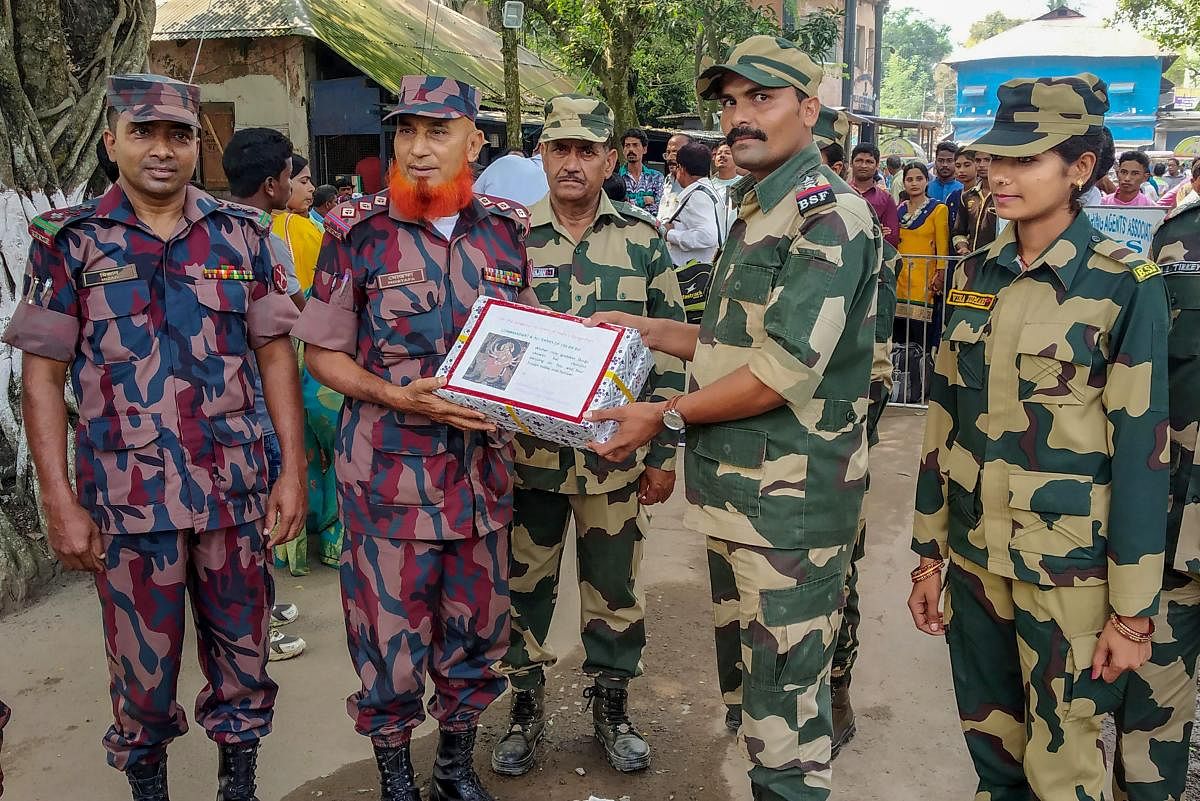 Border Security Force (BSF) and Border Guard of Bangladesh (BGB) officials greet each other on the occasion of Durga Puja festival, at the International Check Post in South Dinajpur. PTI