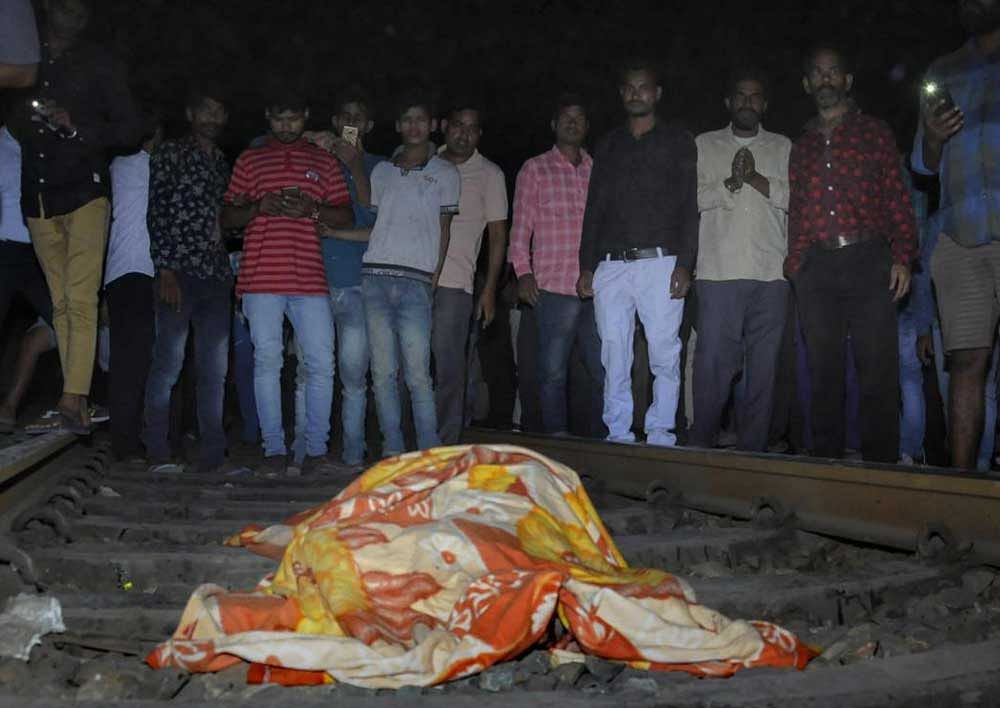 People gather near the body of a victim at the site of a train accident at Joda Phatak in Amritsar on Friday. Officials said at least 60 bodies have been found and many more injured have been admitted to a government hospital after the accident near the site of Dussehra festivities. PTI Photo