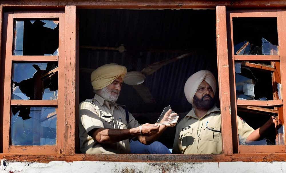 Policemen show dismantled objects at the guard room of a railway crossing caused by protesting agitators, at Shivala in Amritsar. PTI Photo