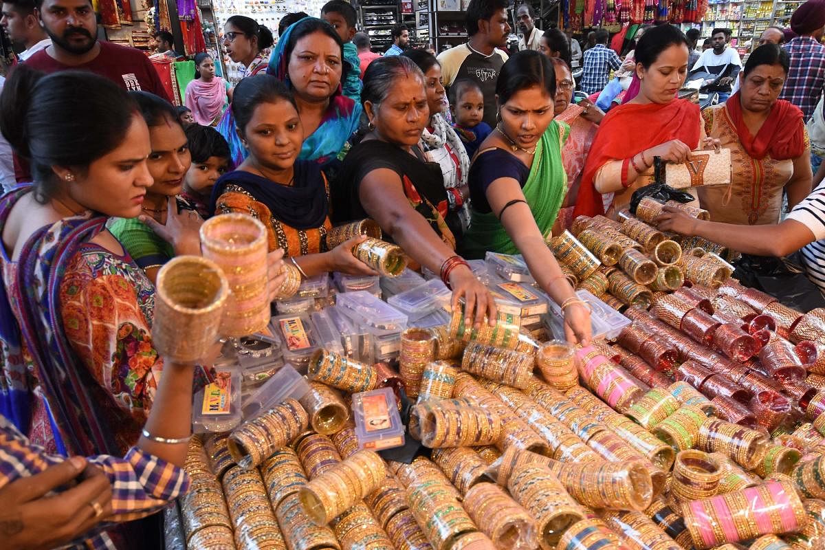 Women browse through bangles on display at a stall on the eve of the