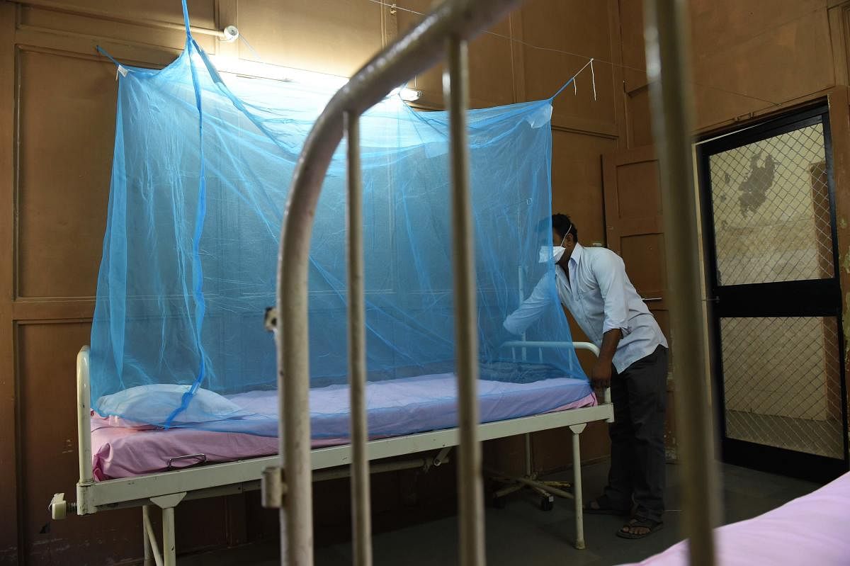 An attendant places a mosquito net to a bed at an isolation ward for Zika Virus patients at Ahmedabad Municipal Corporation run Vadilal Sarabhai (VS) Hospital in Ahmedabad on October 27, 2018. - Gujarat Health Department started taking precautions against Zika virus by major cleanliness drive and preparing Isolation Wards in Ahmedabad hospitals for possible Zika affected patients. (Photo by SAM PANTHAKY / AFP)