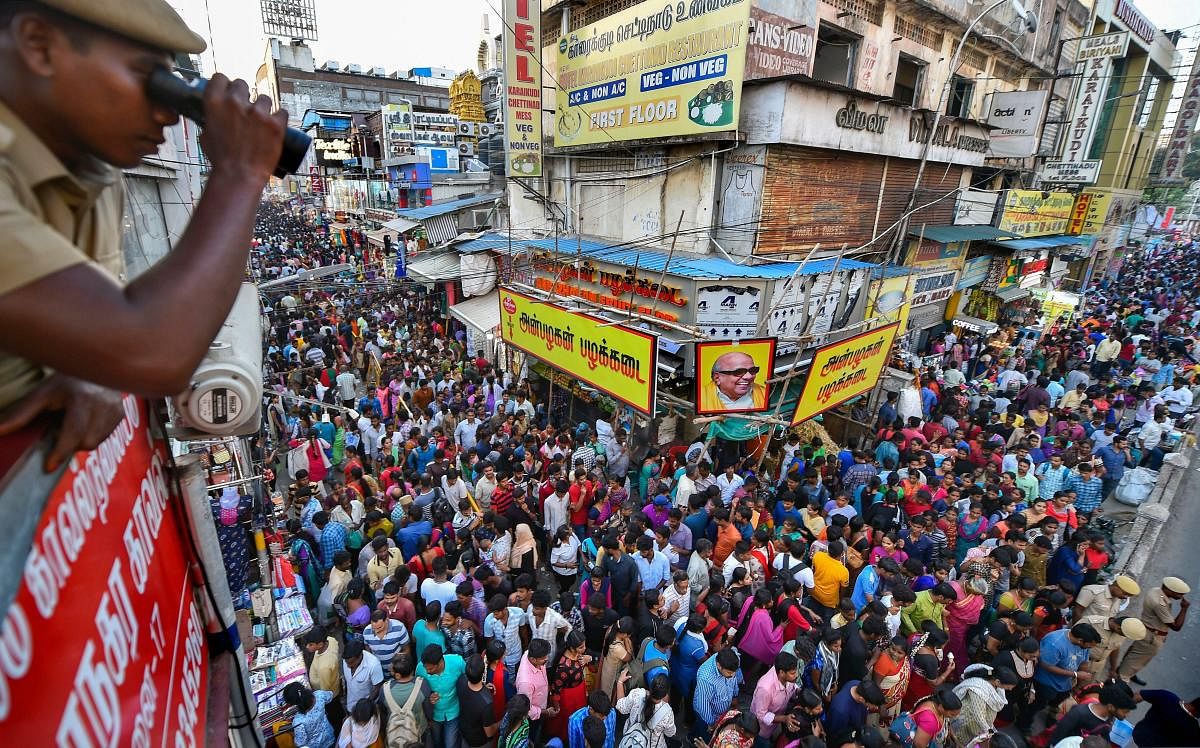A security personnel keeps watch on the crowd packed area of Ranganathan Street during Diwali shopping, in Chennai, Sunday, Oct 28, 2018. (PTI Photo)