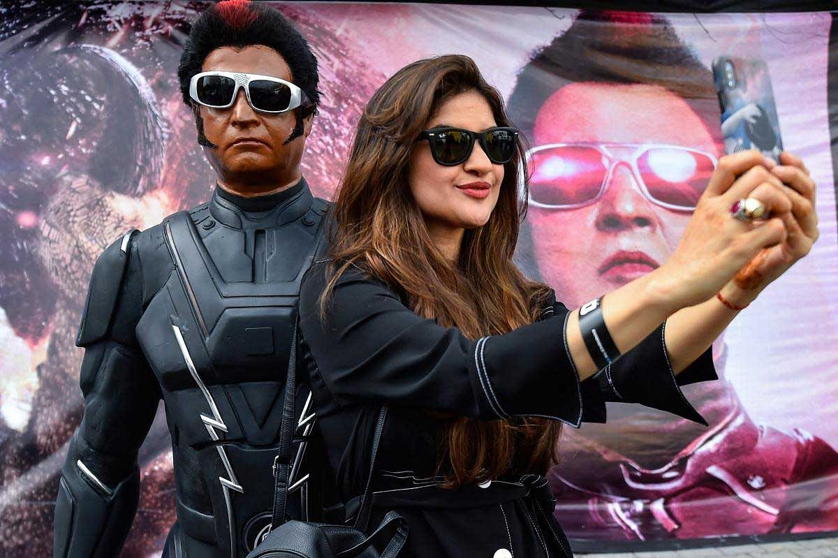A fan takes a selfie with a statue of Tamil Superstar Rajinikanth at the launch of the trailer of film '2.0' in Chennai, Saturday, Nov 3, 2018. (PTI Photo)