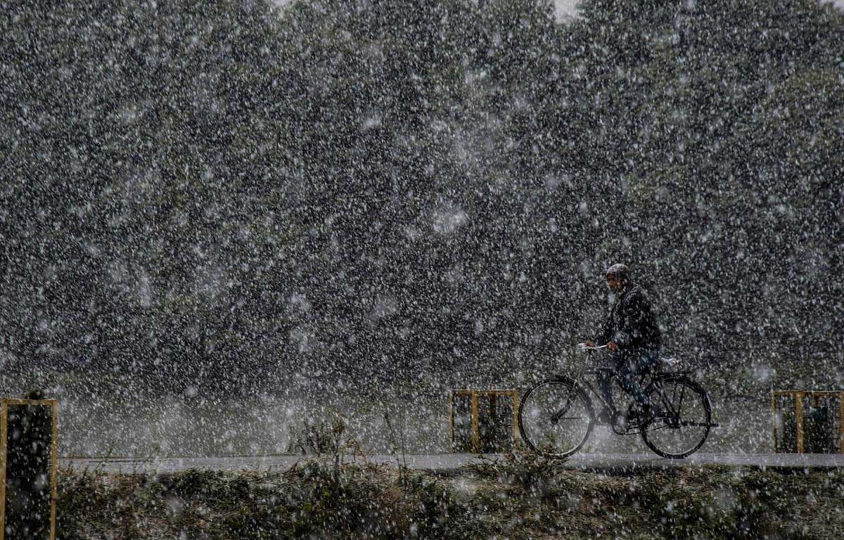 A man rides a bicycle during season's first snowfall in Srinagar, Saturday, Nov 3, 2018. ( PTI Photo/S Irfan)