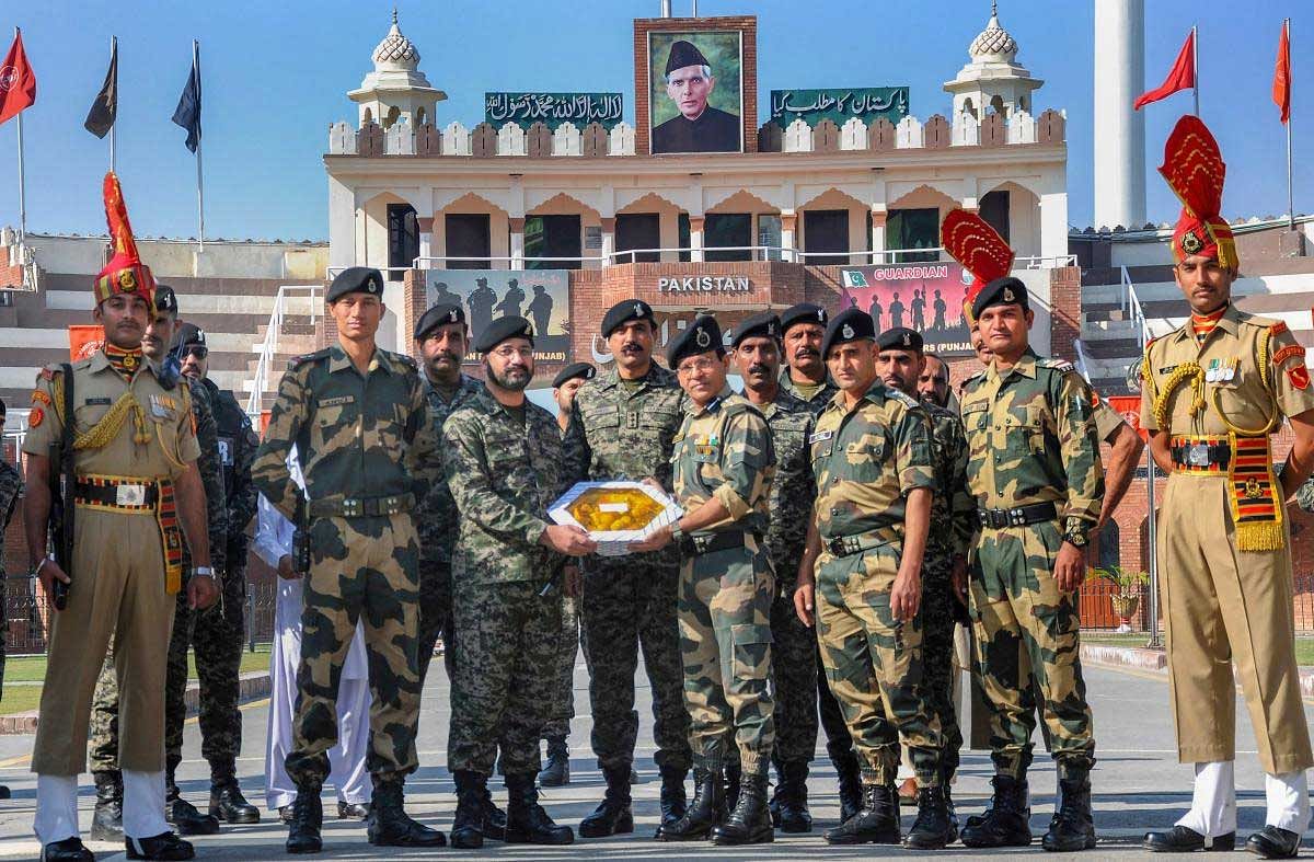 Pakistani border wing commander Usman Khalid (L) exchanges a gift of sweets with his Indian counterparts Border Security Force Commandant Sudeep on the occasion of the Diwali festival at the India-Pakistan Wagah border near Amritsar on Wednesday, November 7, 2018. PTI Photo
