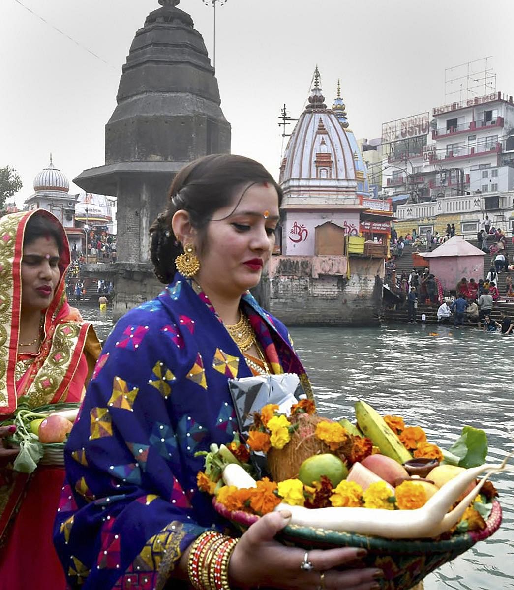 Devotees offer prayers to the Sun god after taking bath in River Ganga on occasion of Chhat puja in Haridwar, Tuesday, Nov 13, 2018. (PTI Photo)