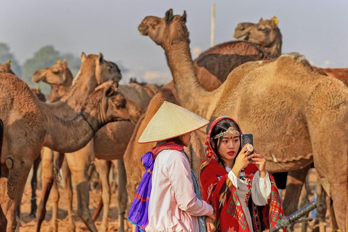 Tourists dressed in traditional attire take a selfie at the annual Pushkar Camel Fair 2018, in Pushkar. PTI photo