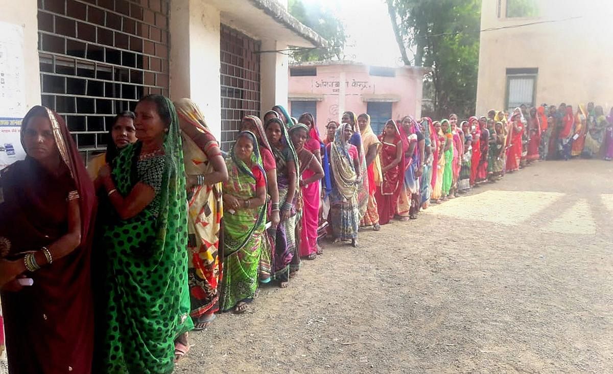 Women stand in a queue to cast their votes at a polling booth during the Assembly Election, in Banahil. PTI Photo
