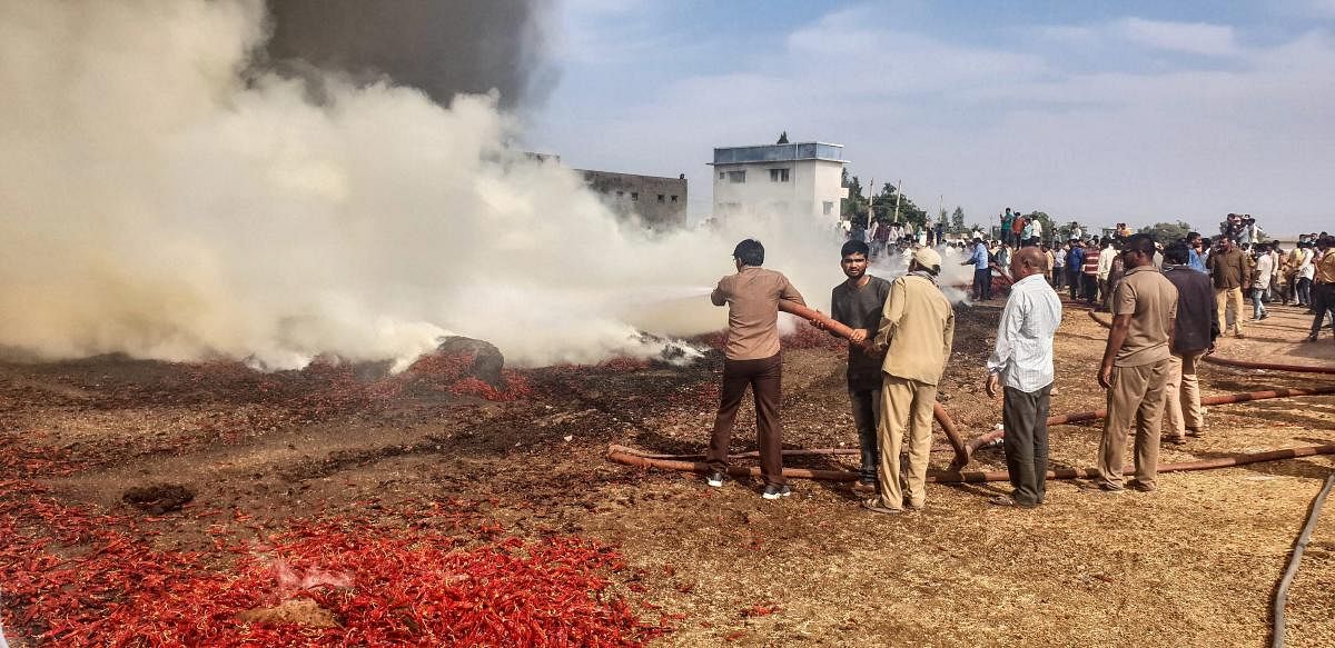 Rajkot: Fire personnel try to control fire at a red chilli heap after a fire broke out in Agriculture Product Marketing Committee (APMC) yard at Gondal town in Rajkot district of Gujarat, Wednesday. (PTI Photo)