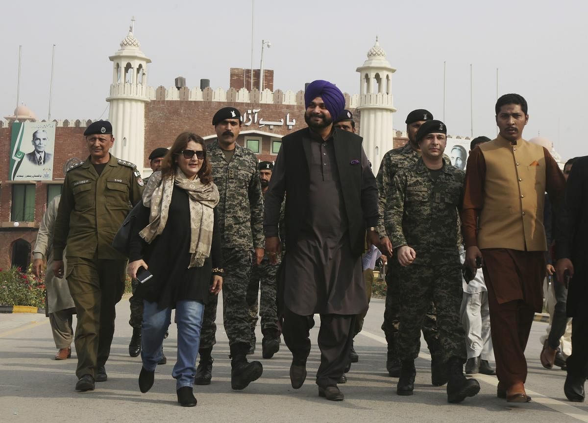 Wagha : Former Indian cricketer-turned-politician Navjot Singh Sidhu, center, arrives at the Pakistani border post Wagha near Lahore, Pakistan, Tuesday, Nov. 27, 2018. Sidhu led his country's delegation to Pakistan for the groundbreaking ceremony of Kartarpur corridor on Wednesday, to give access to Indian Sikh pilgrims to visit the shrine of their spiritual leader Guru Nanak Dev in Pakistan. AP/PTI Photo