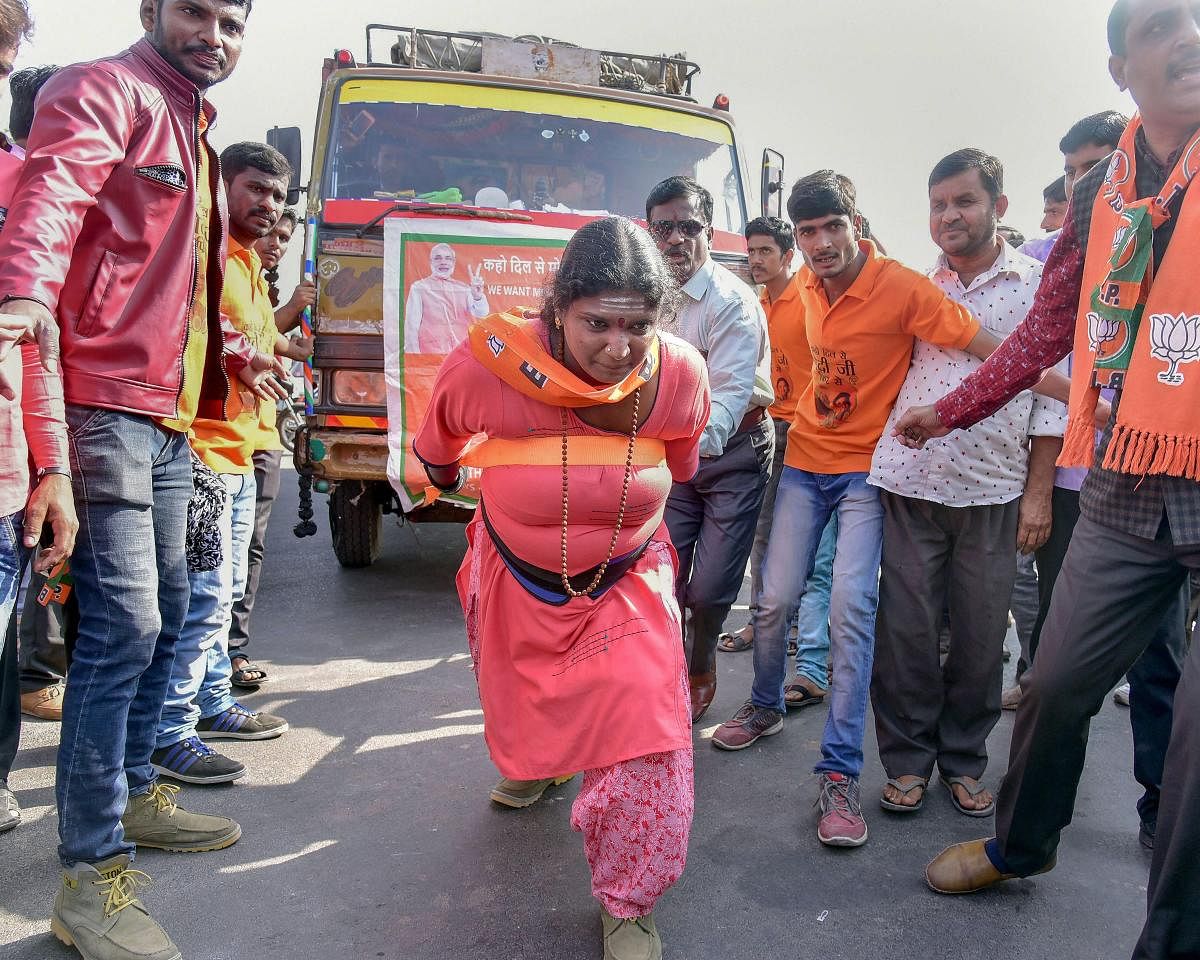 Bikaner: Tamil Nadu's Rajalaxmi Manda, who has achieved several feats needing physical strength, pulls a truck during a BJP election campaign rally in Bikaner, Thursday, Nov. 29, 2018. (PTI Photo)
