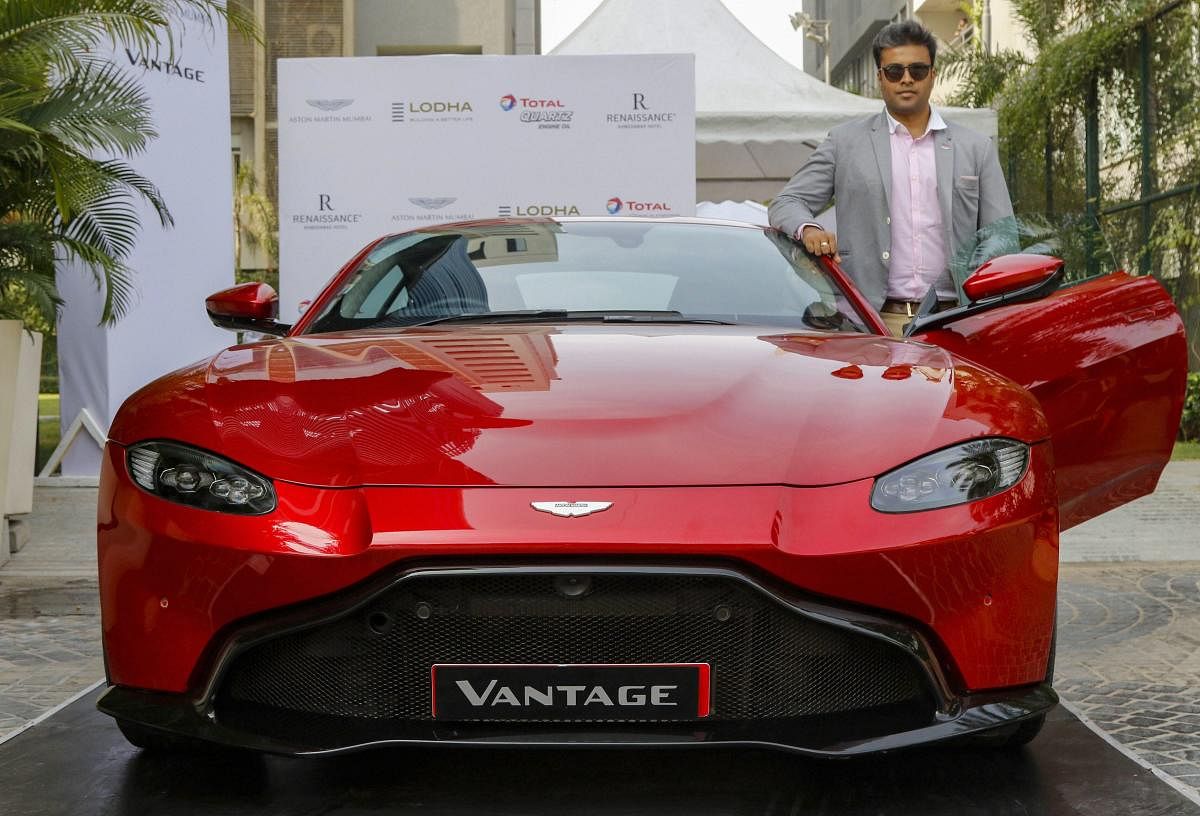 Aston Martin India Business Head Sandeep Gupta poses for photos with newly-launched Aston Martin V8 Vantage car, in Ahmedabad. (PTI Photo)