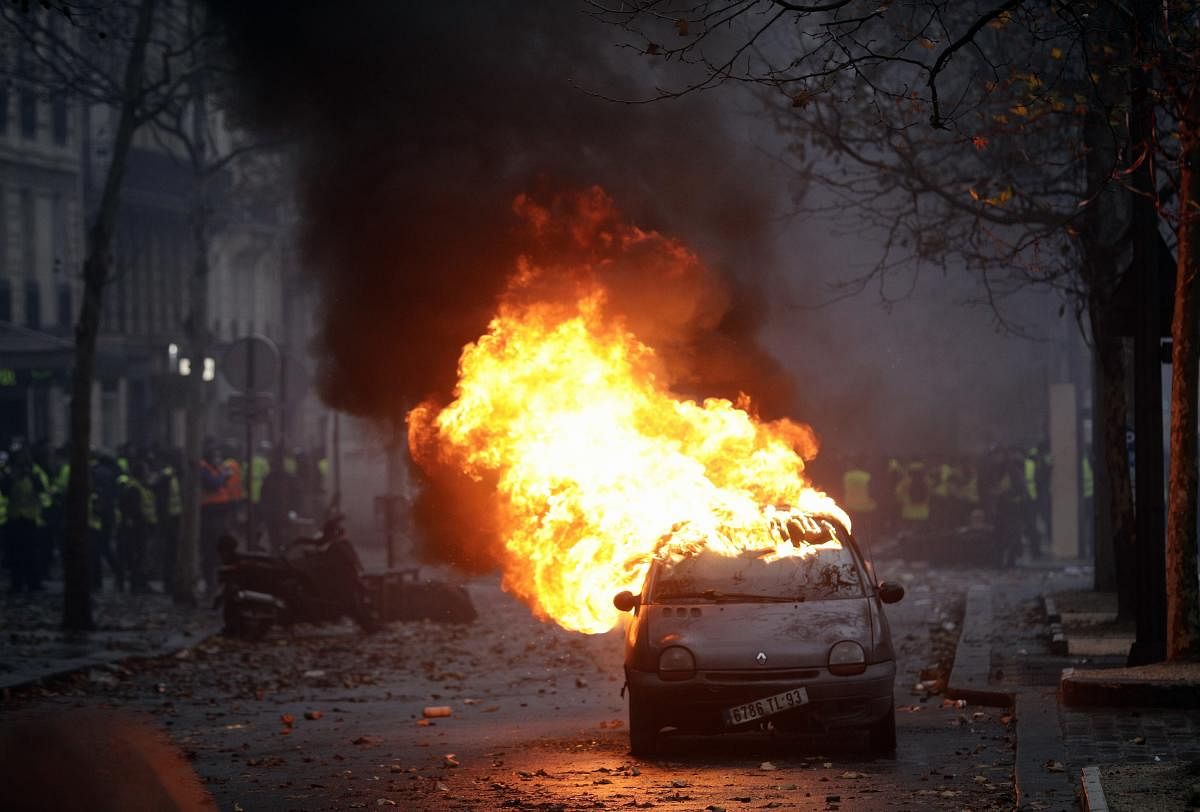 A car burns near the Champs-Elysees avenue during a demonstration in Paris. French authorities have deployed thousands of police on Paris' Champs-Elysees avenue to try to contain protests by people angry over rising taxes and Emmanuel Macron's presidency. (AP/PTI Photo)